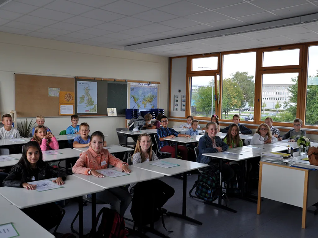 Blick in einen Klassenraum mit Kindern an den Tischen.